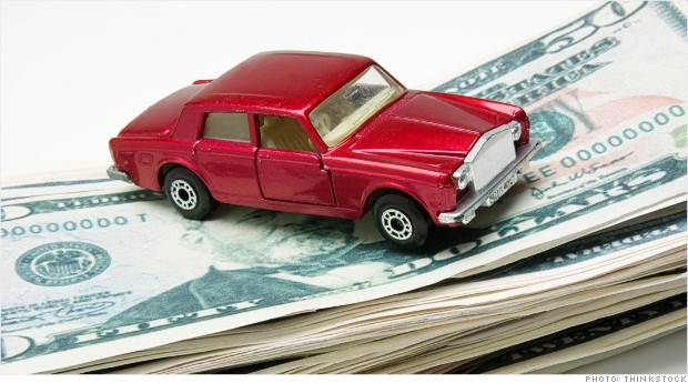 Miniature car on stack of money